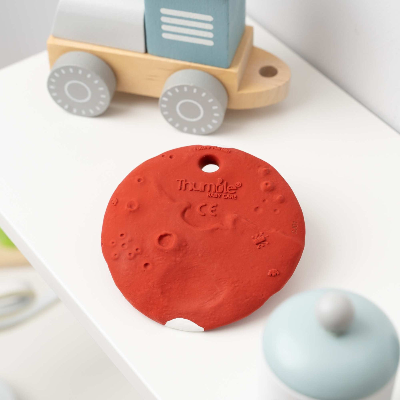 Mars Biscuit Natural Rubber Space Toy on a shelf by Thumble Baby Care
