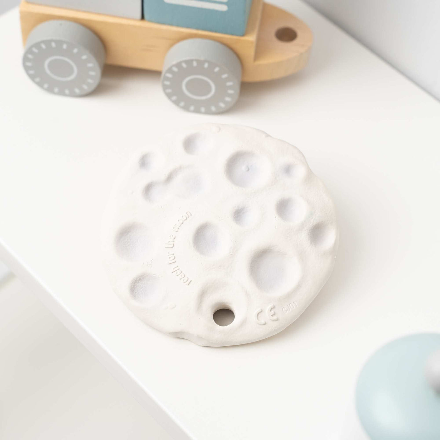 Moon Biscuit Natural Rubber Space Toy on a shelf by Thumble Baby Care