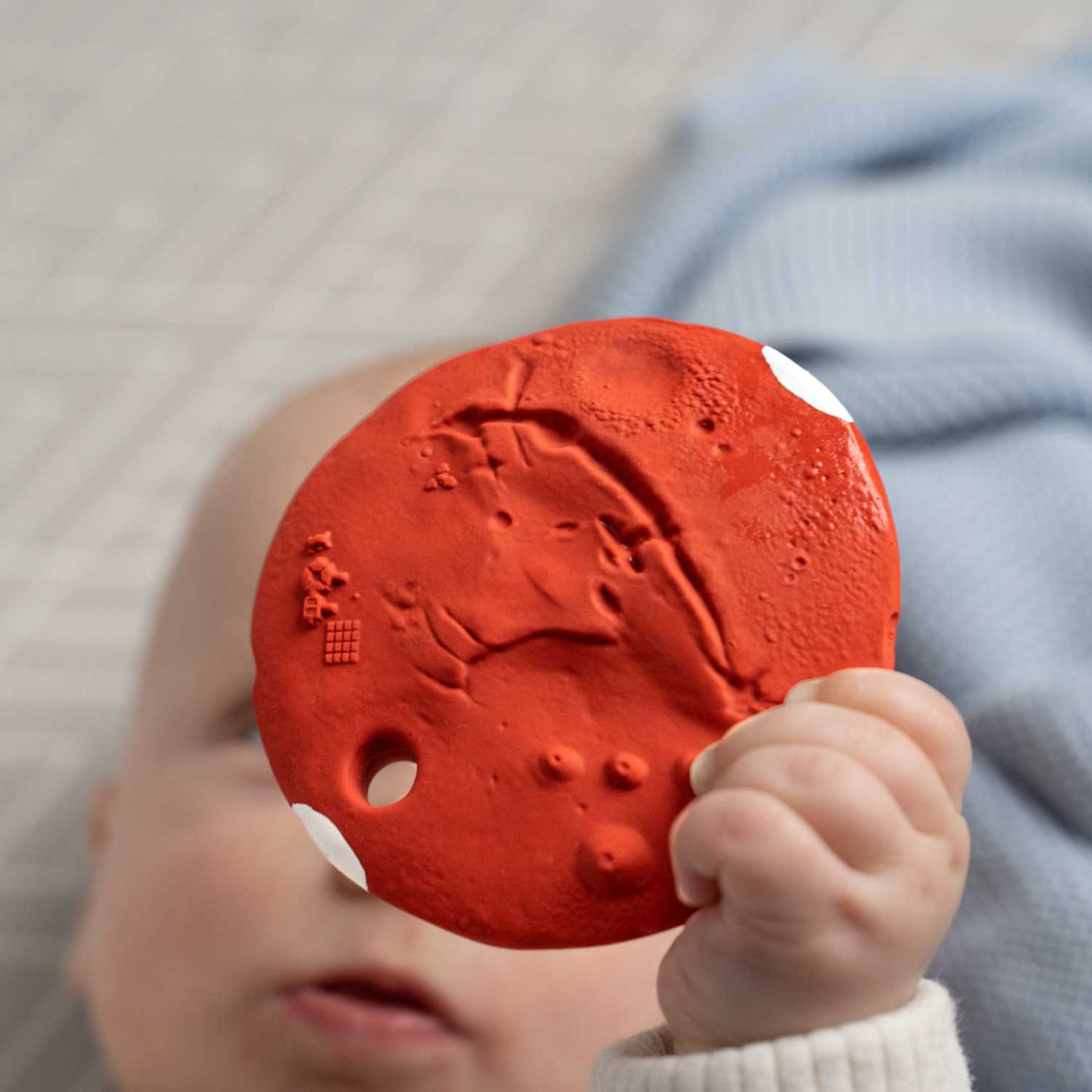 Mars Biscuit Natural Rubber Space Toy being held by a baby by Thumble Baby Care